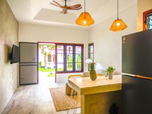 eine Küche mit einem Kühlschrank und einem Tisch im Zimmer in der Unterkunft Tropical Nusa Residence in Koh Samui 
