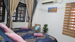 a room with a bed and a couch and windows at Rumah Inap Haziq in Seri Manjung +8 photos