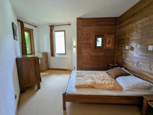 a bedroom with a bed and a wooden wall at Billy Avoriaz - Chalet Mont Oya in Morzine
