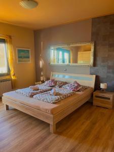 a bedroom with a large bed with a mirror at Apartment Vesna in Supetarska Draga