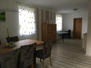 ein Wohnzimmer mit einem Holztisch und Stühlen in der Unterkunft Ferienhaus Hochbrand in Rabenstein