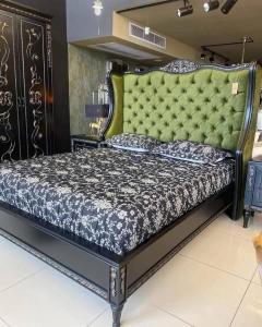a bedroom with a large bed with a green headboard at Grand Lodge E11 in Rawalpindi