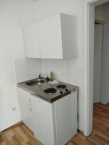 a kitchen with a sink and white cabinets at Gästehaus Kreuz in Blaustein
