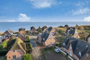 an aerial view of a town with houses and the ocean at Wattküken in Munkmarsch