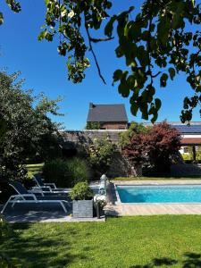 ein Pool mit Stühlen und ein Haus im Hintergrund in der Unterkunft Propriété à la campagne in Rièzes