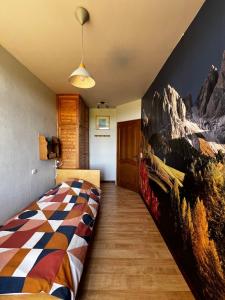 ein Schlafzimmer mit einem Bett mit einem Wandbild der Berge in der Unterkunft Propriété à la campagne in Rièzes