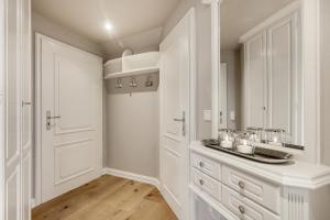 a white kitchen with a sink and a mirror at Wattküken in Munkmarsch +20 photos