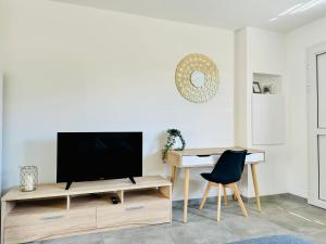 a living room with a television on a wooden entertainment center at La Kaz Eden * * * * in Les Cocos
