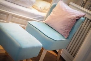 a blue chair with a pillow next to a bed at Wattküken in Munkmarsch