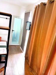 a bedroom with orange curtains in a room with a door at Kalo Shipping Container in Christiansborg +1 photo