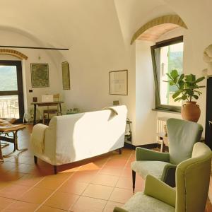 a living room with a couch and two chairs at Sbilenca Sbilenchina - Charming Houses, Garden & BBQ for Climbers, MTB Lovers & Families in Calice Ligure