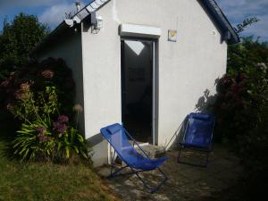 two blue chairs sitting outside of a house at Châtaigne in Plouézec +7 photos