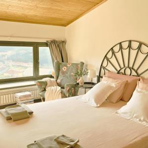 a bedroom with a bed and a chair and a window at Sbilenca Sbilenchina - Charming Houses, Garden & BBQ for Climbers, MTB Lovers & Families in Calice Ligure