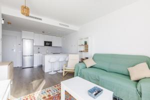 ein Wohnzimmer mit einer grünen Couch und einer Küche in der Unterkunft A&N La Vega 26, Torre del Mar in Almayate Bajo