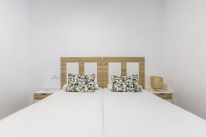 ein großes weißes Bett mit zwei Kissen darauf in der Unterkunft A&N La Vega 26, Torre del Mar in Almayate Bajo + 66 Fotos
