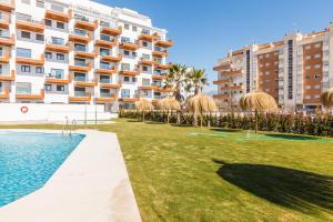 ein großes Apartmenthaus mit Rasen und Pool in der Unterkunft A&N La Vega 26, Torre del Mar in Almayate Bajo