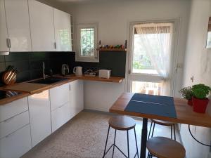 a kitchen with white cabinets and a blue counter top at Grande maison 3 chambres - Jardin, terrasse et parking - Bord de mer in Torreilles