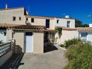a house with white doors and a driveway at Grande maison 3 chambres - Jardin, terrasse et parking - Bord de mer in Torreilles