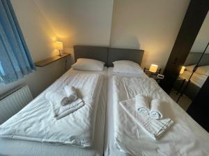a bedroom with two beds with towels on them at Fewo 4 OG Sylt Westerland in Süderende