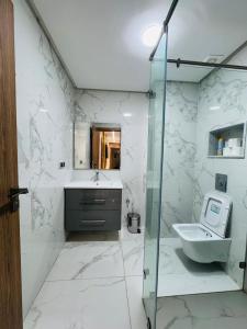 a white bathroom with a sink and a toilet at Lusail in Beni Mellal +60 photos