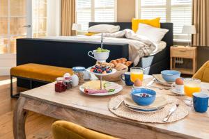 a breakfast table with breakfast foods on it in a bedroom at B&B 't Gemeentehuis in Biervliet