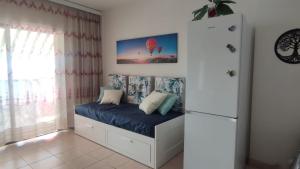 a bedroom with a bed with blue sheets and a refrigerator at Ladybug Ocean View in Costa Del Silencio +30 photos