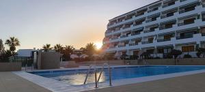 a hotel with a swimming pool in front of a building at Ladybug Ocean View in Costa Del Silencio