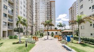 a park with benches and palm trees and buildings at Cozy Place Curitiba in Curitiba