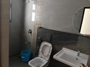 Un baño con inodoro, lavabo y espejo. en Homestay 2Bhk, en Hinjawadi