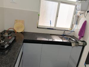 encimera de cocina con fogones y ventana en Homestay 2Bhk, en Hinjawadi 1 foto más