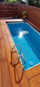 a swimming pool on a wooden deck with a pool at La Villa Day **** in Les Cocos