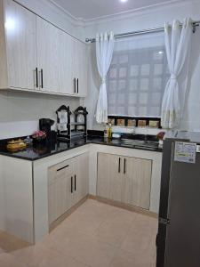 a kitchen with white cabinets and black counter tops at Lakeview Elegance in Nakuru
