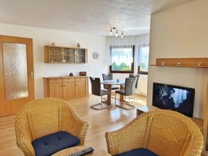 a living room with a table and chairs and a television at Baltique - Ferienwohnung 1 Glowe in Glowe