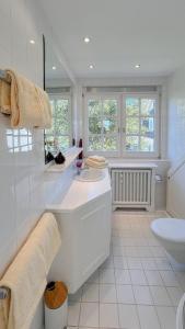 une salle de bain blanche avec un lavabo et des toilettes dans l'établissement Heefwai 2 - W4, à Morsum 9 autres photos