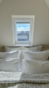 - une chambre avec 2 lits avec des oreillers et une fenêtre dans l'établissement Heefwai 2 - W4, à Morsum