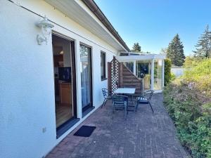 Un patio con una mesa y sillas al costado de una casa. en Baltique - Ferienwohnung 2 Glowe, en Glowe