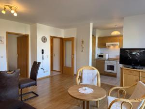 Una sala de estar con una mesa y una cocina. en Baltique - Ferienwohnung 2 Glowe, en Glowe 6 fotos más