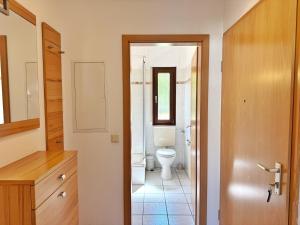 Un baño con inodoro, lavabo y puerta. en Baltique - Ferienwohnung 2 Glowe, en Glowe