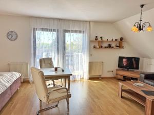 Sala de estar con mesa, cama y TV en Baltique - Ferienwohnung 3 Glowe, en Glowe