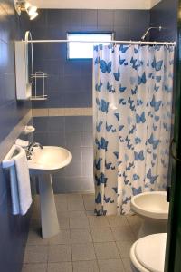 baño con lavabo y cortina de ducha en Cabañas Dolce Vita I en Los Reartes