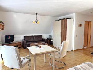 una sala de estar con un sofá, una mesa y sillas en Baltique - Ferienwohnung 3 Glowe, en Glowe