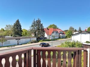 Una vista de una calle desde un balcón con un coche. en Baltique - Ferienwohnung 3 Glowe, en Glowe