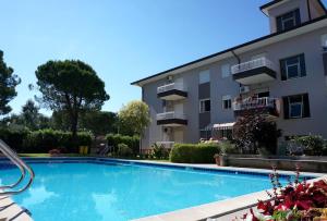 a swimming pool in front of a building at Enjoy the pool in our cozy flat in Porto Santa Margherita di Caorle