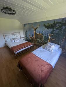 ein Schlafzimmer mit 2 Betten und einem Hirschgemälde in der Unterkunft Notre Renardière, Gîtes à Saulxures-sur-Moselotte, Hautes-Vosges in Saulxures-sur-Moselotte