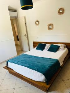 a bedroom with a bed with blue and white sheets at Villa 3 chambres avec piscine et parking privés in Calenzana