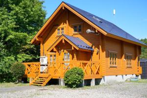 a large wooden cabin with a wooden staircase in front at Sakata Log House - Vacation STAY 32306v in Sakata