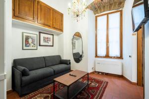 un soggiorno con un divano e un tavolo di 2BDR - Duomo & Uffizi - Chic Residence of the Cerchi by Hôtea a Firenze