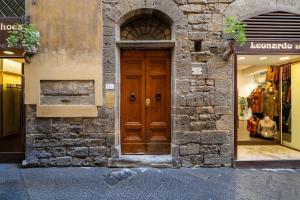 una porta di legno sul lato di un edificio di 2BDR - Duomo & Uffizi - Chic Residence of the Cerchi by Hôtea a Firenze