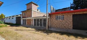 ein Backsteingebäude mit einem Tor und einer Garage in der Unterkunft El Corazón de Villa in Villa del Carbón