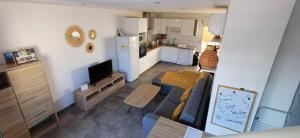 a living room with a couch and a kitchen at La Villa Day **** in Les Cocos